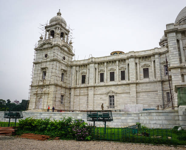 Courtyard view of the historic Srirampur Dey Raj Bari in West Bengal, featuring tall Corinthian-style columns, arched windows, and vibrant rangoli on the floor. The colorful blue, green, and yellow accents highlight Indo-European architectural fusion. A cultural landmark symbolizing tradition, artistry, and the grandeur of Bengal’s heritage mansions.