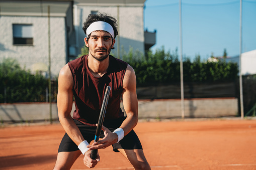 Male hands tying shoelaces of padel sneaker on the court next to the net before the match. Sport bets in betting shops.