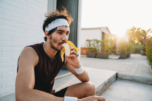 A tennis player is eating a banana during a break