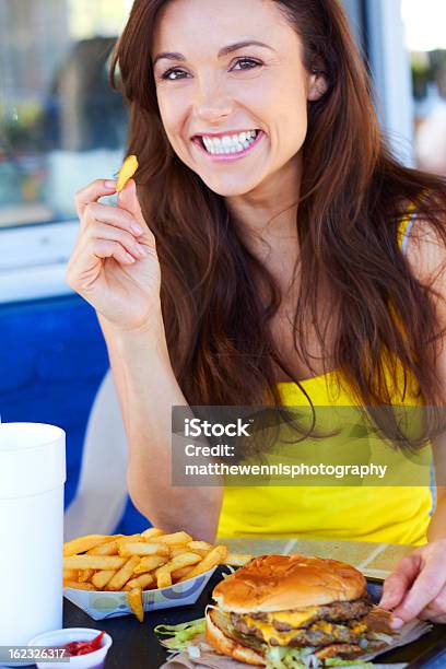 Photo libre de droit de Jeune Femme Manger Des Frites banque d'images et plus d'images libres de droit de Manger - Manger, Pommes frites, Prise de vue en extérieur