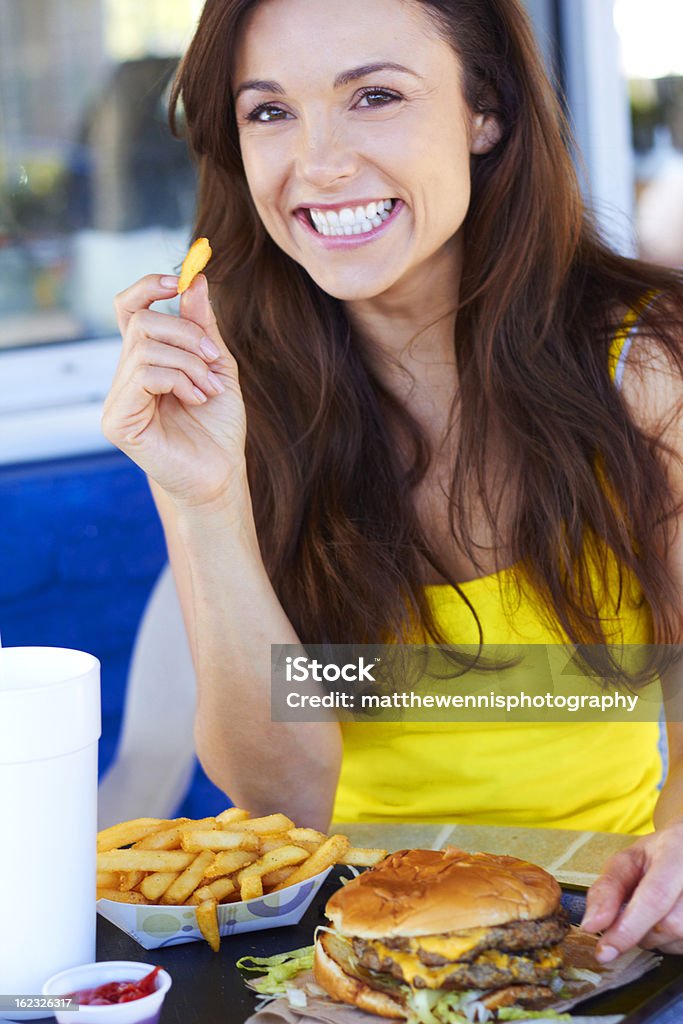 Giovane donna mangiare Patatine fritte - Foto stock royalty-free di Ambientazione esterna