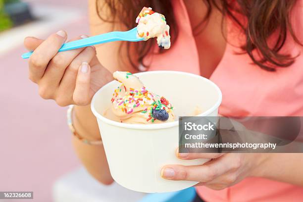 Mujer Comiendo Frozen Yogurt Con Bayas Foto de stock y más banco de imágenes de Yogur helado - Yogur helado, Comer, Helado - Comida dulce congelada