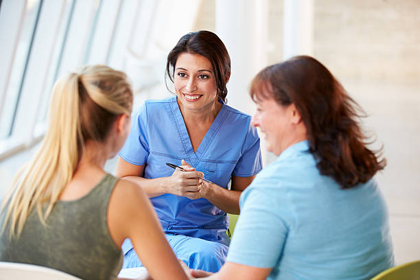 Nurse sharing good news with a teenage girl and her mother Nurse Meeting With Teenage Girl And Mother In Modern Hospital Smiling girl patient stock pictures, royalty-free photos & images