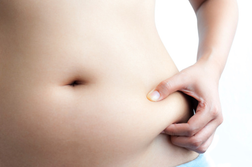 Mujer asiática Pellizcar grasa en el vientre con la mano izquierda photo