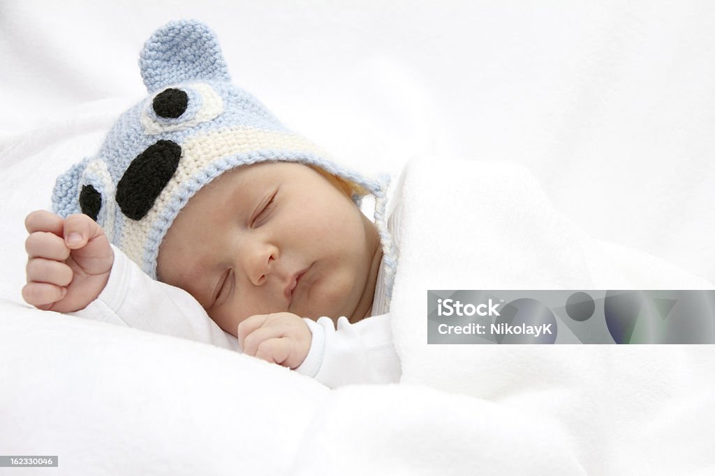 Baby sleeping with a blue beanie on Sleeping baby with knitted hat Baby - Human Age Stock Photo