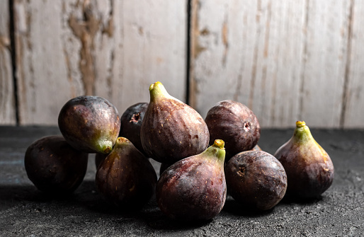Group of ripe figs of the Bordissot variety in front of a rustic wooden fence