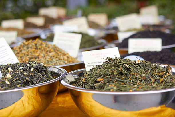hojas de té recién preparado para la venta en tazones - tea tea leaves jasmine tea leaf fotografías e imágenes de stock