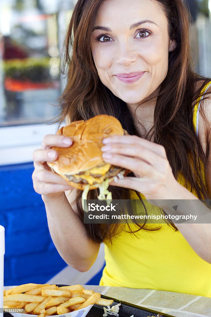 Belle jeune femme ayant Hamburger - Photo de Burger libre de droits