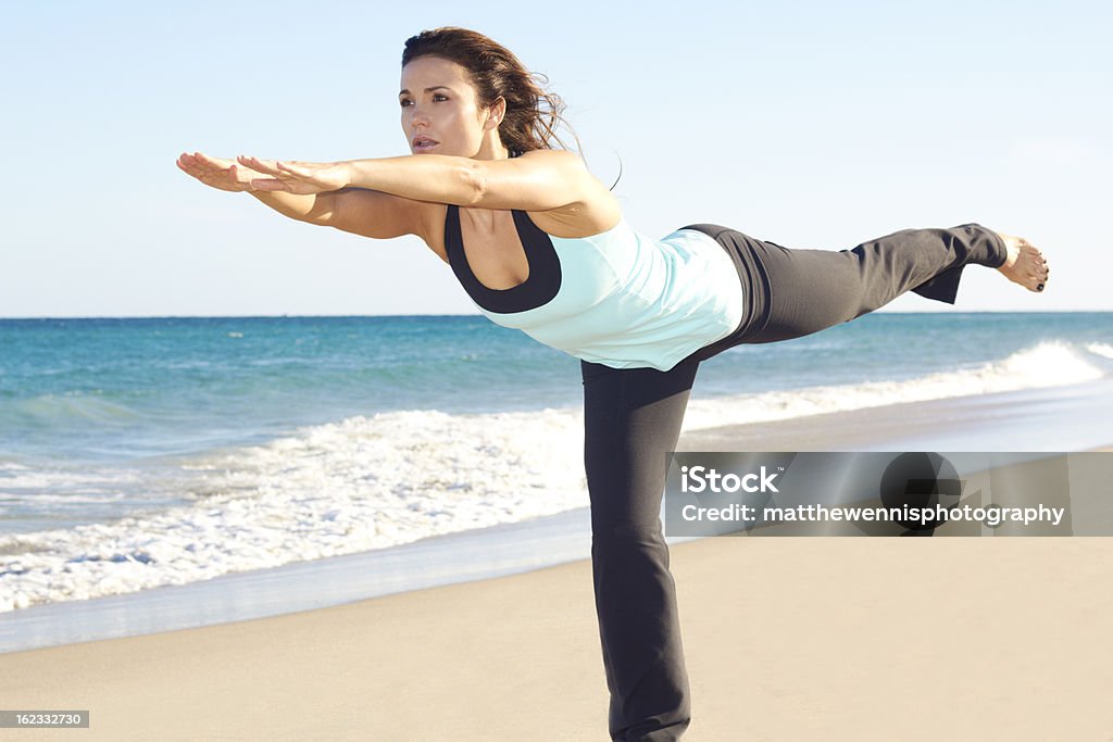 Bella donna facendo yoga in spiaggia - Foto stock royalty-free di Acqua