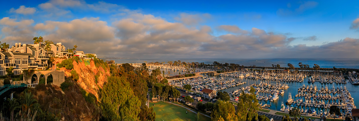 Sunset over luxury homes, yachts, and boats in Dana Point harbor, Orange County in Southern California on a cloudy day