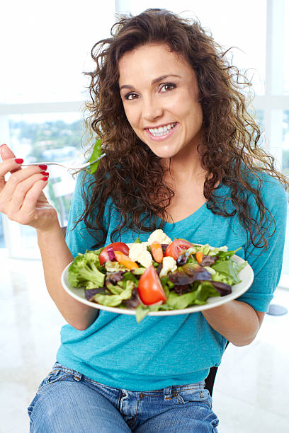 istock Beautiful happy female eating a salad 162333095