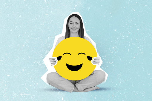 happy girl holding large laughing, crying smiley emoji collage isolated on blue color background
