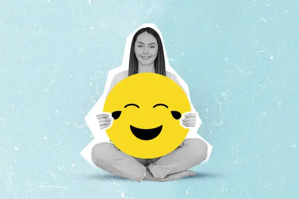 Photo of happy girl holding large smiley emoji collage isolated on blue color background