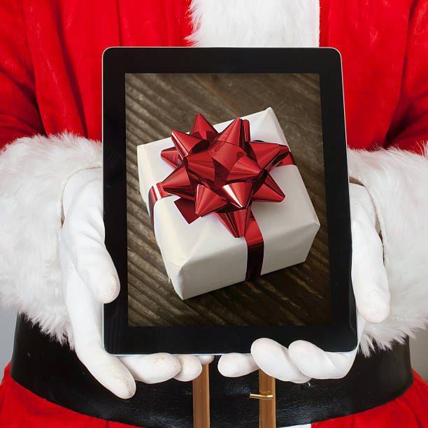 istock Santa Claus Showing a Gift in to his Digital Tablet 162334696