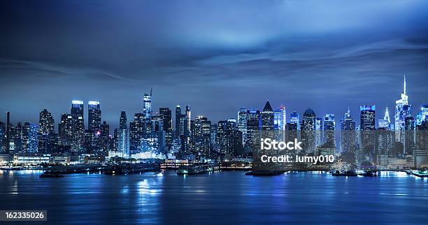 Horizonte De Manhattan Por La Noche Foto de stock y más banco de imágenes de Noche - Noche, Ciudad de Nueva York, Panorama urbano