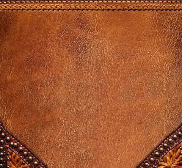 istock Leather background of brown and black colors with bronze rivets. Decorative backdrop with brown and black color cowhide texture.  Copy space for text 1623364615