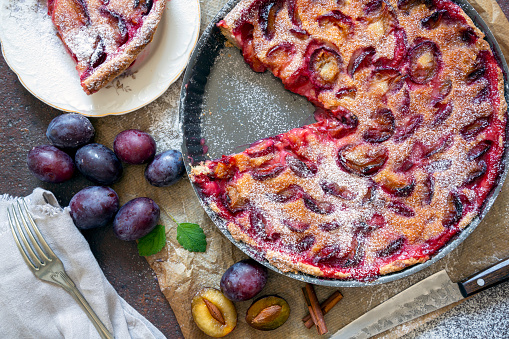 Homemade pie with plums on the table.