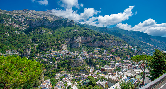 Positano Amalfi Coast Italy a place with colorful houses that can be seen on the coast and blue sky in the background .