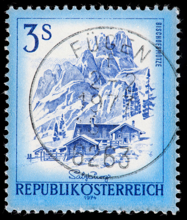 Austrian Postage Stamp Illustrating Snowy Mountains and Rustic Villa in Blue-tones.