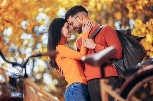 Young couple being in love. Sunny autumn day in colorful park