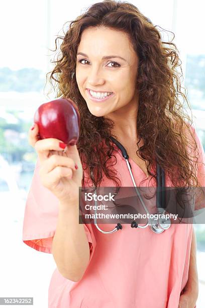 Glückliche Junge Krankenschwester Hält Einen Apfel Stockfoto und mehr Bilder von Apfel - Apfel, Halten, Ärztin