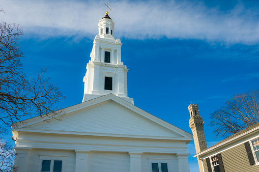 The beautiful architecture of the 
Church of the Redeemer, Provincetown Massachusetts (1847) considered by many to be the oldest building on lower Cape Cod   still in its original state and being used for its original purpose, stands with the tower of the Pilgrim Monument in the background.