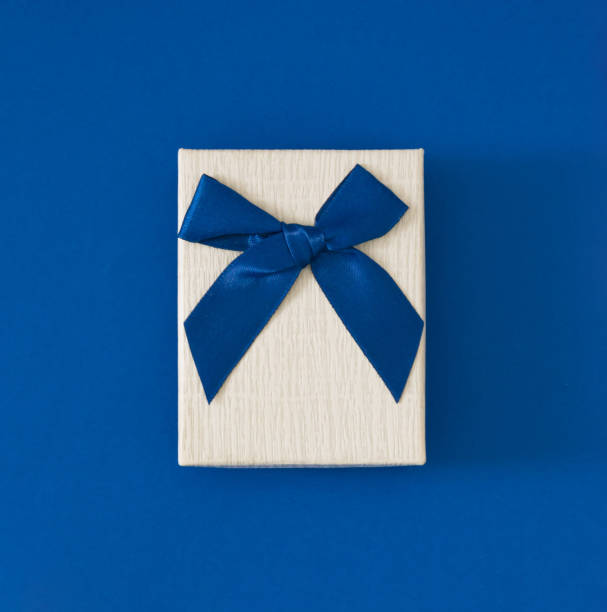 istock Closeup view minimal composition of Christmas gift box on blue backdrop. New Year present concept background. Trendy gift box idea. Gift box aesthetic layout. 1623483696