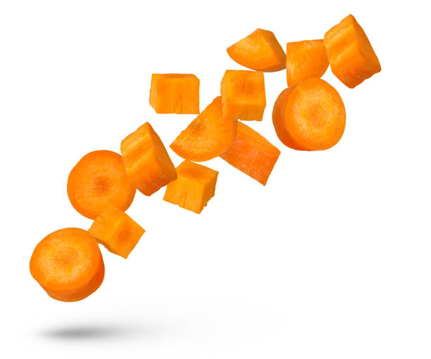 istock Flying vegetables. Carrot slices from different sides scatter in different directions. An isolate of a flying carrot that casts a shadow. 1623497171