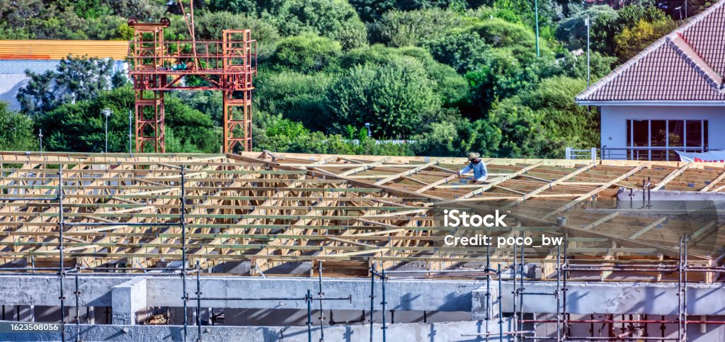 african carpenter  mounting some trusses on the roof african carpenter in the construction industry mounting some trusses on the roof Business Stock Photo