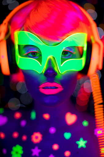 A cool woman dancing with UV fluorescent clothing and makeup