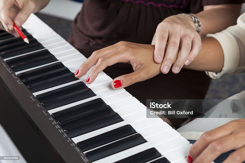 Piano Lessons Woman at piano getting lessons Piano Stock Photo