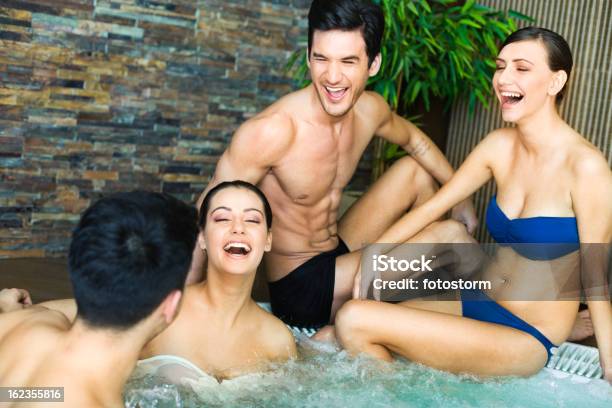 Amici Che Si Diverte Con Vasca Idromassaggio Jacuzzi - Fotografie stock e altre immagini di Bagno caldo