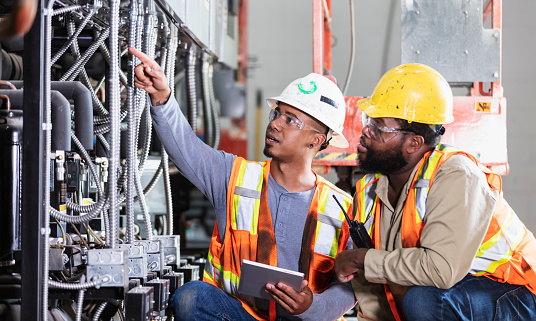 Two workers inspecting industrial refrigeration equipment