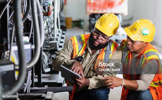 Two Workers Inspecting Industrial Refrigeration Equipment Stock Photo - Download Image Now