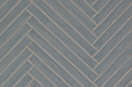 Long blue gray tile pattern with light glaze finish, diagonal pattern on a wall, background image. Color swatch design sample.