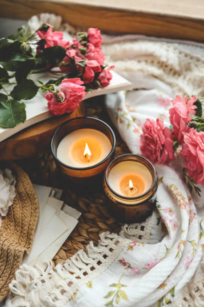 istock Two burning candles, roses and a book, aesthetics 1623637050