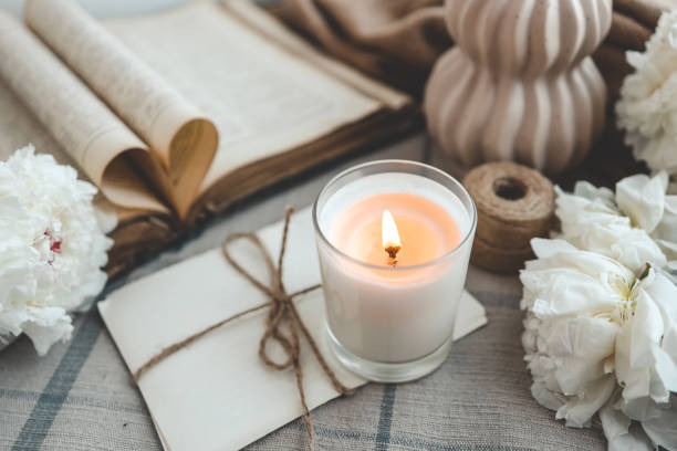 istock Burning candle and white peonies, vintage aesthetic 1623642405