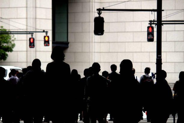 alltag in japan "silhouetten von menschen, die morgens vom bahnhof tokio zur arbeit pendeln" - walking point of view stock-fotos und bilder