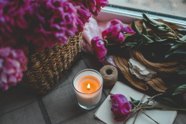 istock Burning candle and pink peonies, vintage aesthetic 1623654757