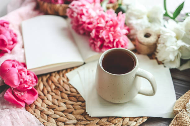 istock Beautiful spring composition, good morning concept. Cup of tea, peonies and open book 1623656431