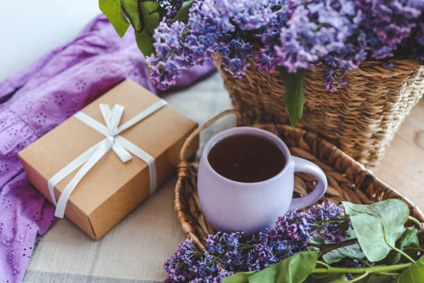 istock Cup of tea, gift box and lilac basket, spring still life 1623674919