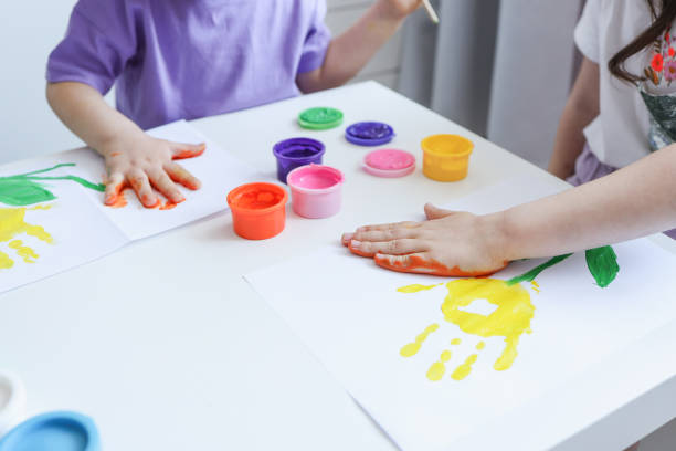 istock Children's drawing workshop, happy children make handprints with paint. 1623679212