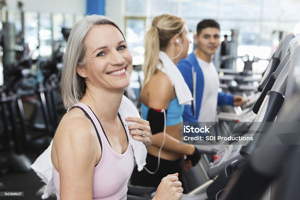 Mature Femme faisant de l'exercice sur le tapis de course dans la salle de remise en forme - Photo de Activité libre de droits