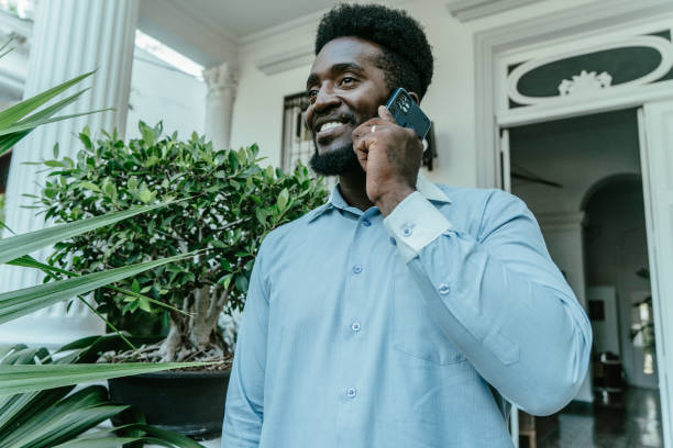 istock Young man talking on mobile phone in front of his house 1623722770