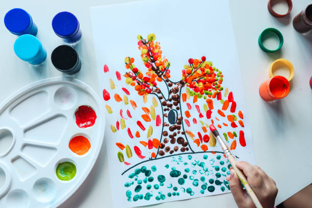 istock Child paints a tree with autumn leaves, art concept 1623723330