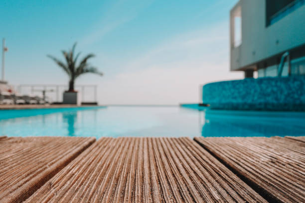 istock Empty wooden deck with swimming pool , Beautiful minimalist pool side view with clear blue sky . Vintage filter color apply 1623724630