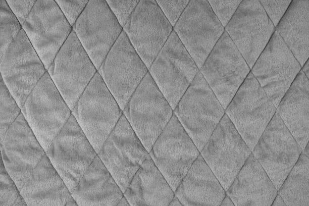 istock Quilted gray velours fabric background, wrinkled soft blanket surface 1623725175