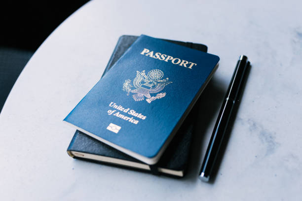 istock A blue American passport and a pen and notebook on a white table 1623795480
