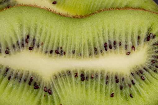 Ripe green kiwi sliced into thin slices, ripe soft green kiwi with black seeds