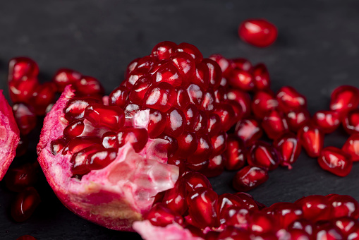 Grains of red ripe pomegranate close-up , juicy pomegranate seeds of red color during cooking